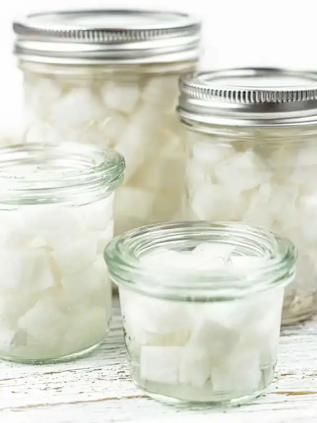 Sugar cubes in jars on a wooden table.