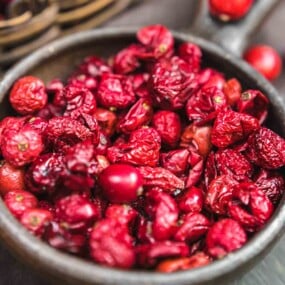 Dried cranberries in a bowl on a table.