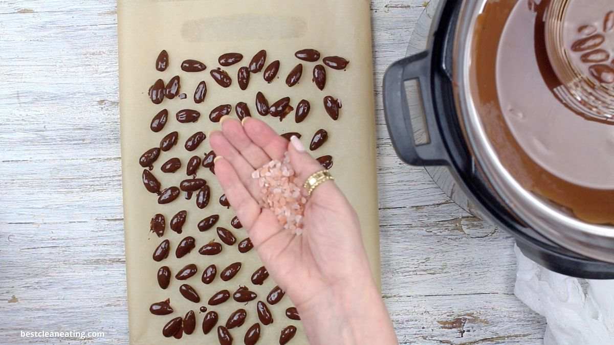 Spreading salt crystals onto almonds.