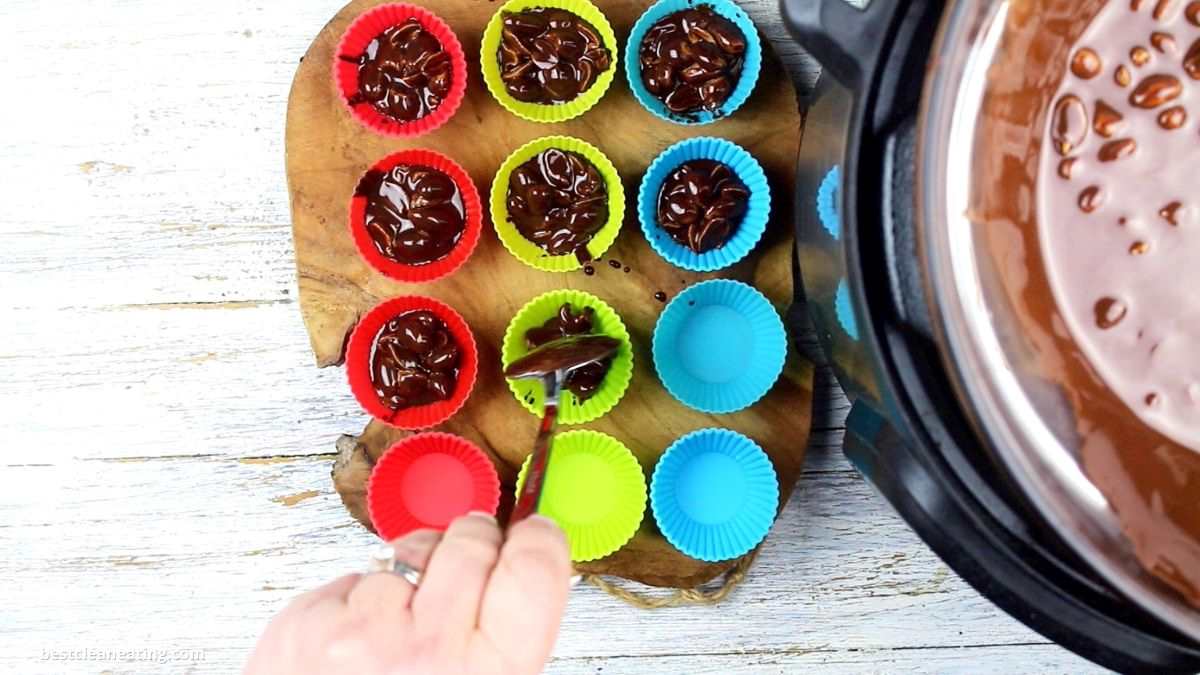 Pouring chocolate into silicone cupcake molds.