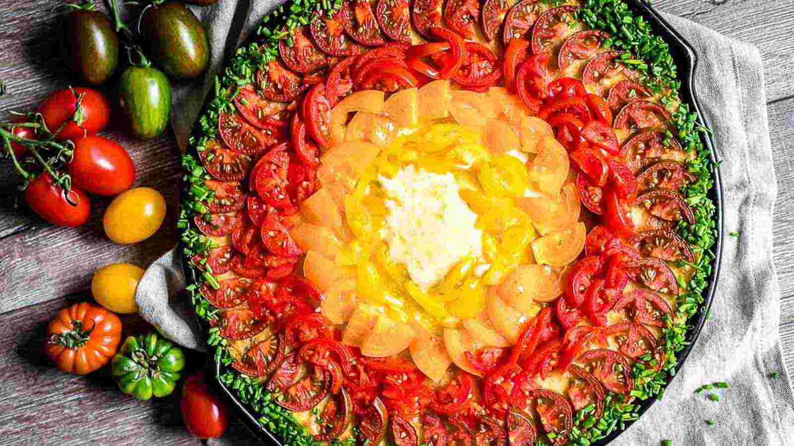 Rainbow Pizza filled with colorful tomatoes and green fresh chives around it.