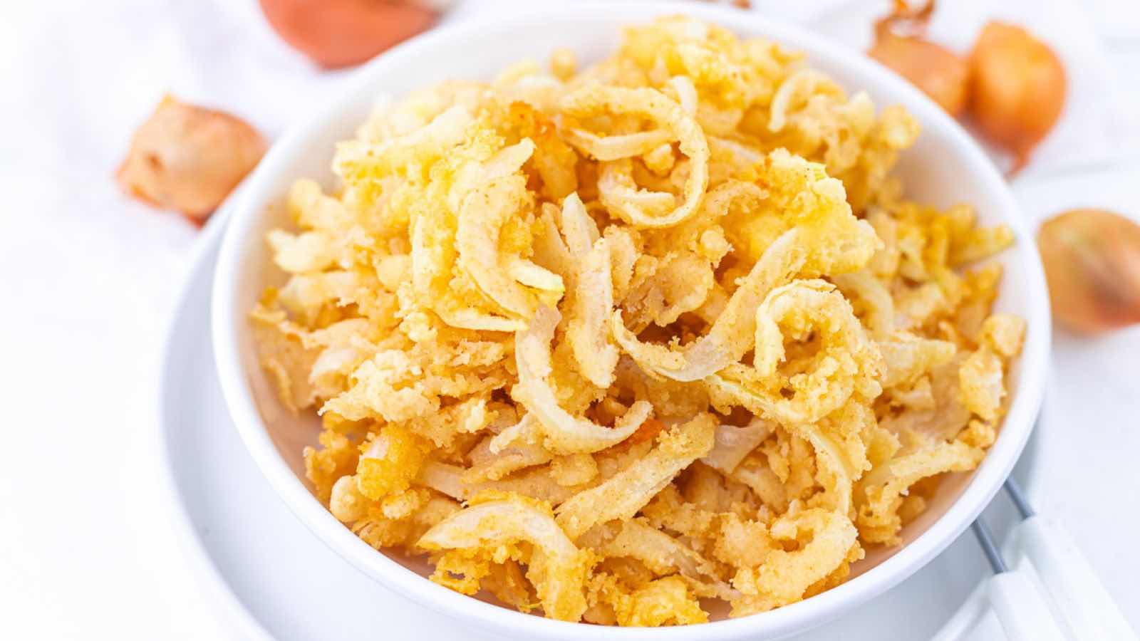 A bowl filled with crispy fried onion strings.