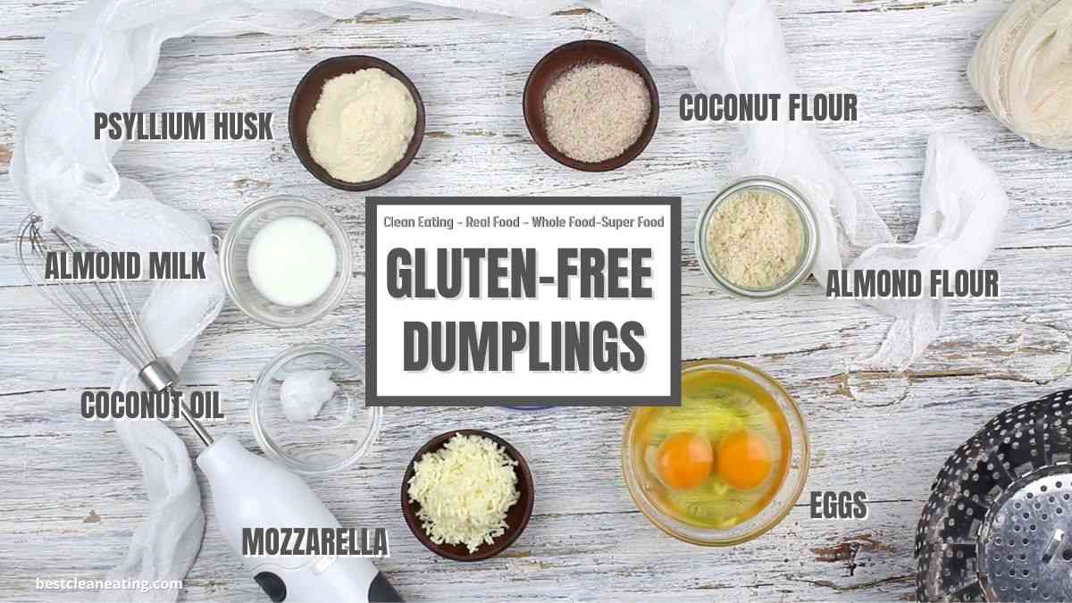 Top view of ingredients for gluten-free dumplings on a white wooden surface, including eggs, almond flour, coconut flour, mozzarella, almond milk, coconut oil, and psyllium husk.