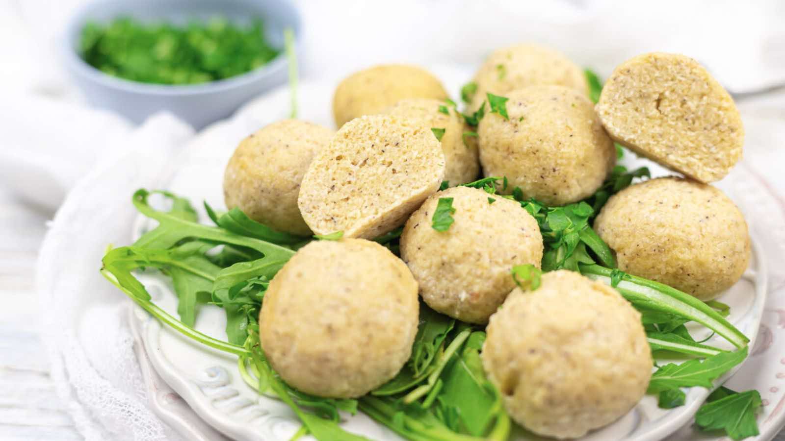 A plate of dumplings on a bed of greens.