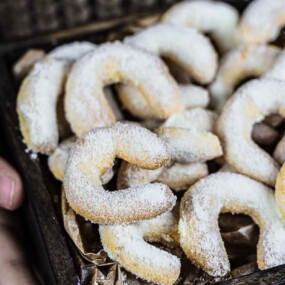 A tray of crescent-shaped cookies dusted with powdered sugar.