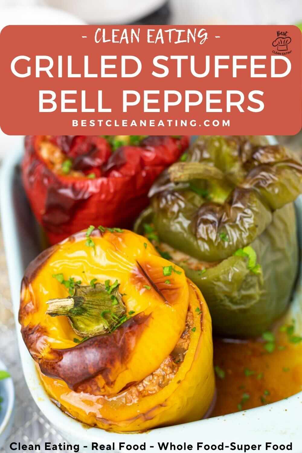 Three grilled stuffed bell peppers in red, yellow, and green, in a baking dish, garnished with chopped herbs.