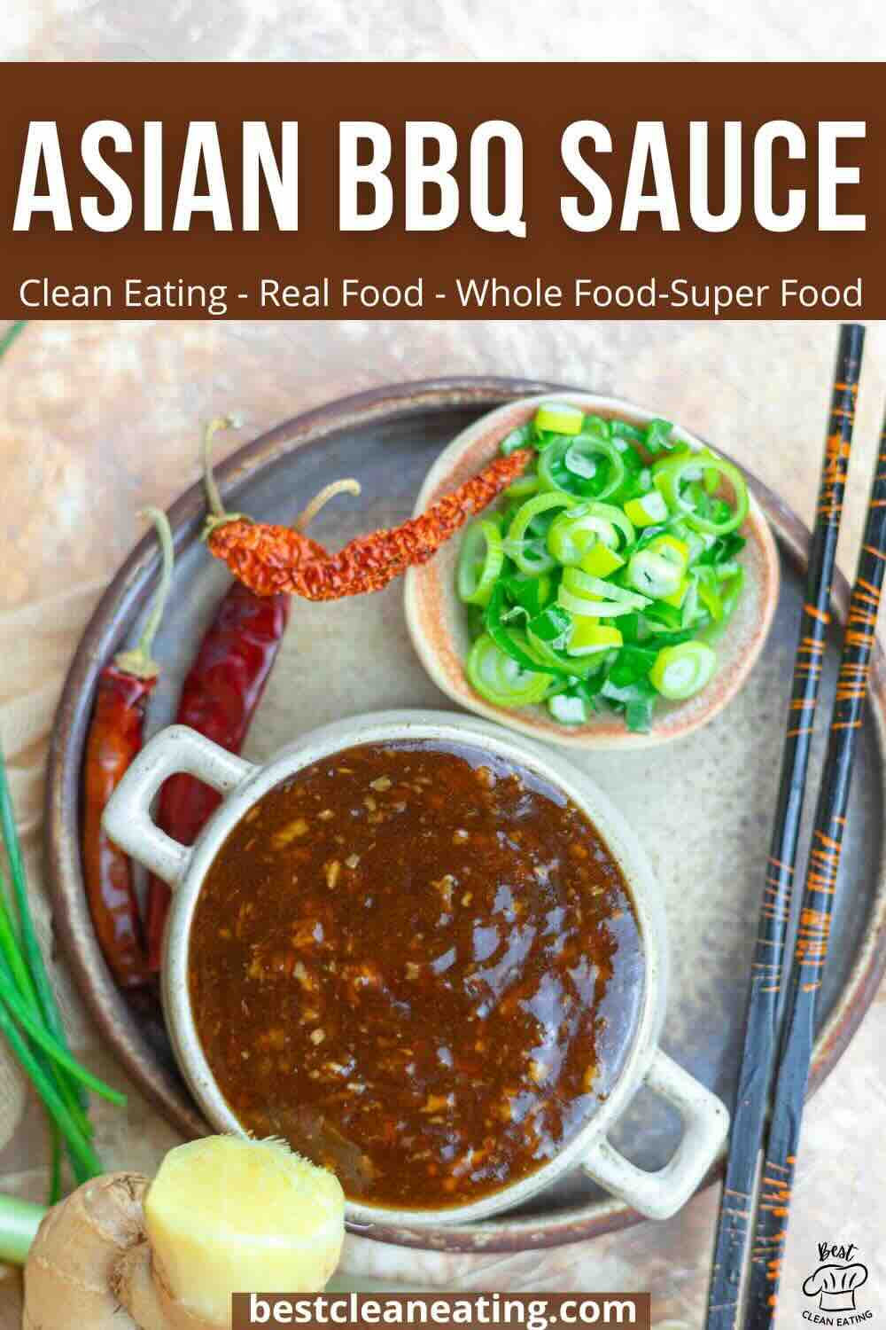 Bowl of Asian BBQ sauce on a plate with green onions, ginger, whole chilies, and chopsticks nearby. Text overlay reads "Asian BBQ Sauce" with clean eating descriptions.