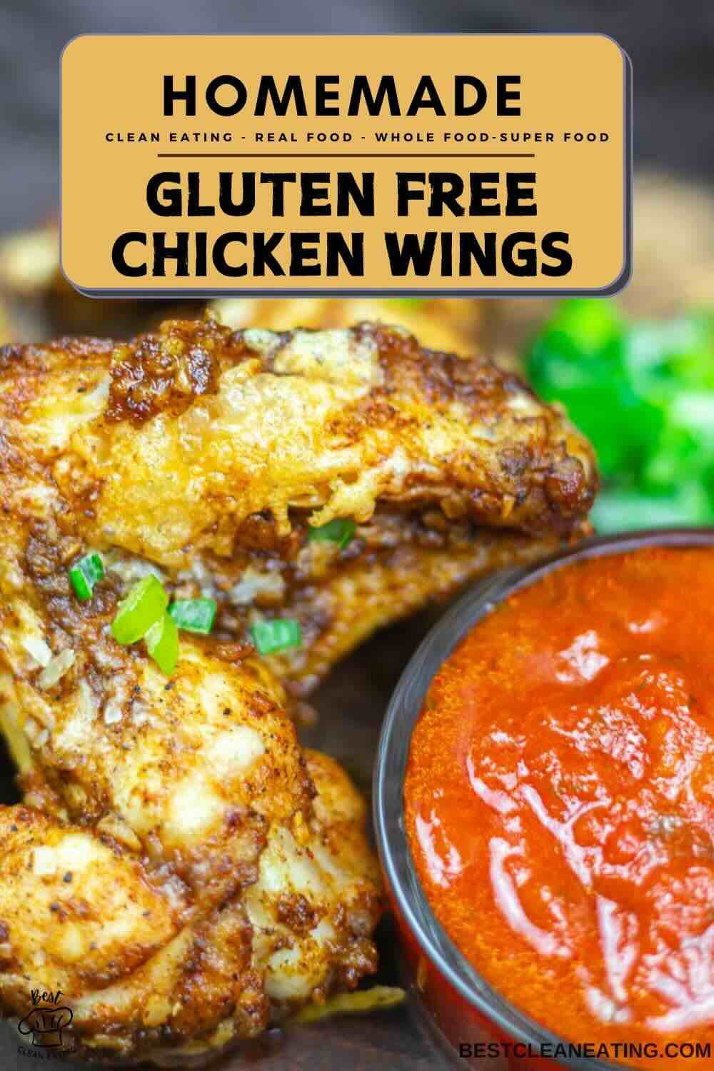 Close-up of gluten-free chicken wings next to a bowl of red dipping sauce, garnished with chopped green onions. Text overlay: "Homemade Gluten Free Chicken Wings.