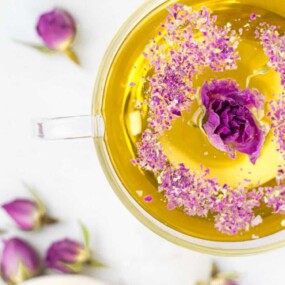 Cup of tea with pink rose ingredients.
