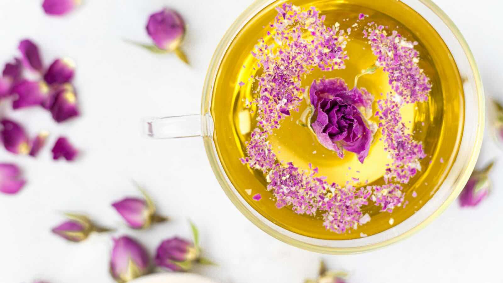 Cup of tea with pink rose ingredients.