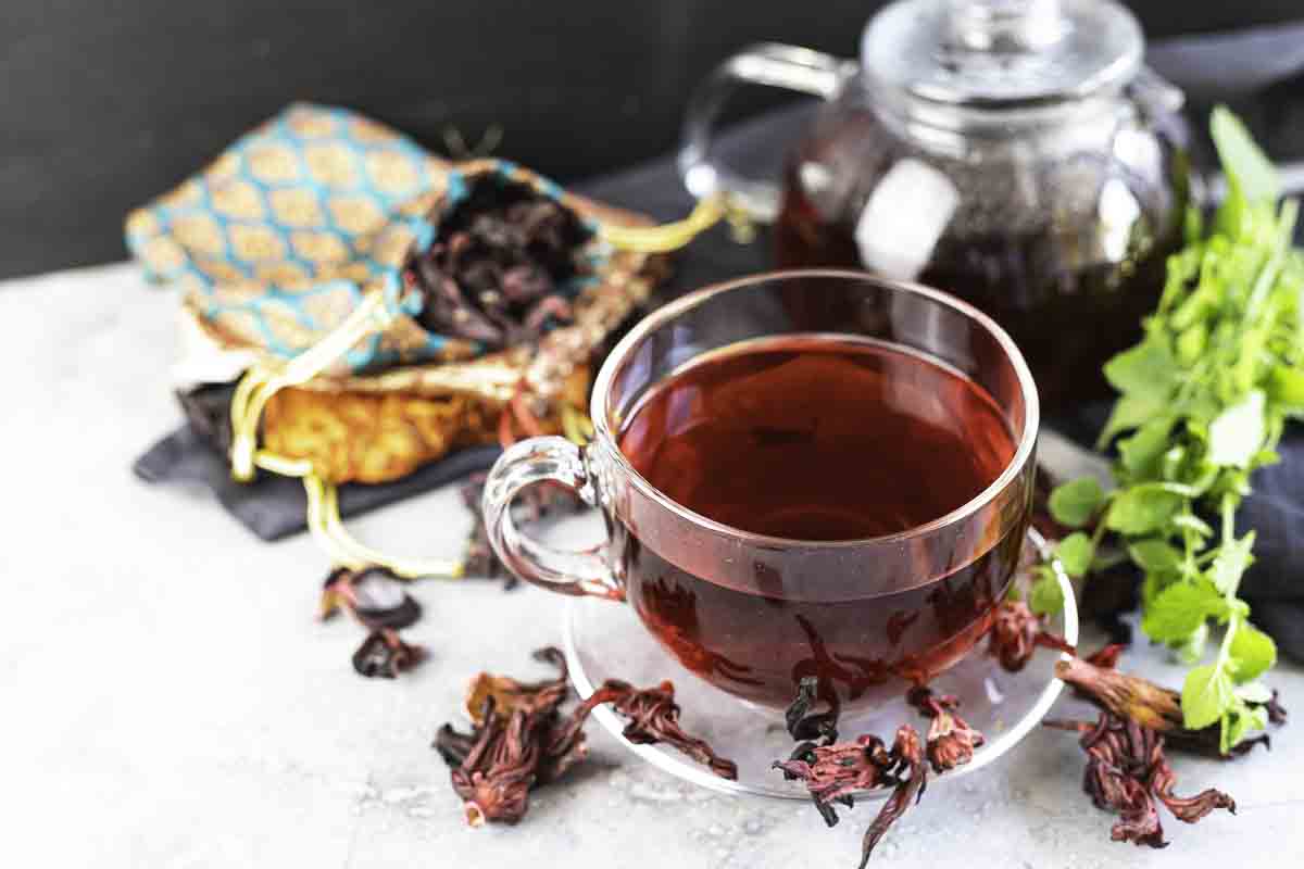 A clear glass cup of hibiscus tea.