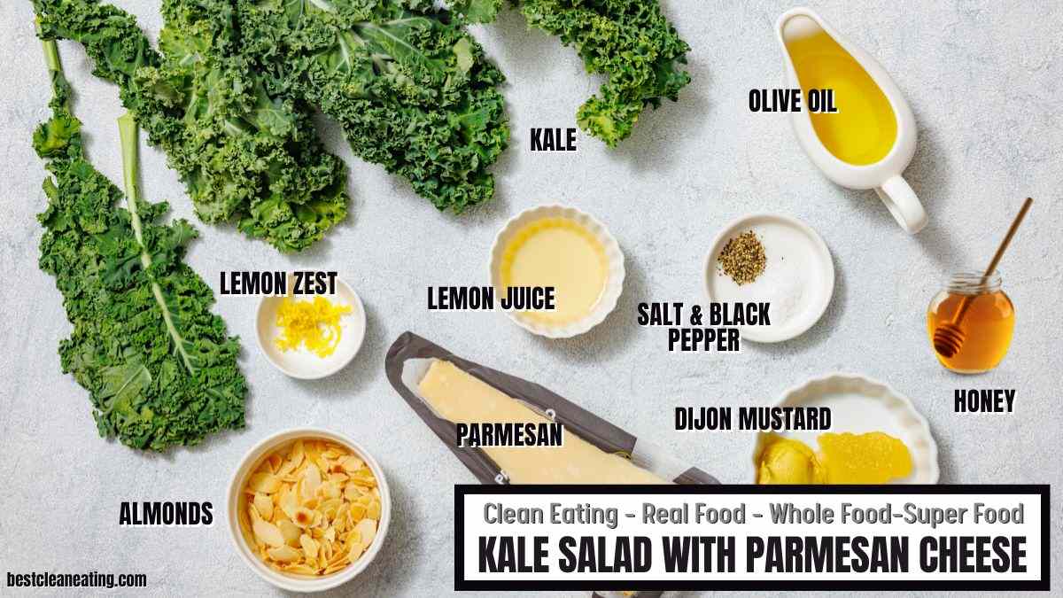 Ingredients for kale salad with parmesan cheese, including kale, lemon zest, lemon juice, parmesan, almonds, salt and pepper, dijon mustard, olive oil, and honey, arranged on a white surface.