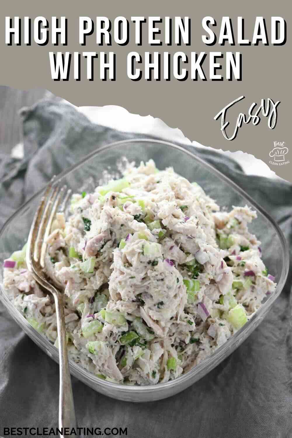 A glass bowl filled with chicken salad containing chopped vegetables, placed on a gray cloth with two forks beside it. Text reads: "High Protein Salad with Chicken. Easy.