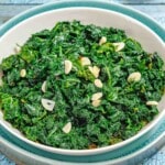 Kale dish placed on textured blue surface.