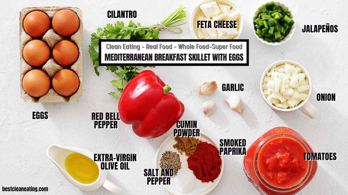 A variety of Mediterranean breakfast skillet ingredients including eggs, cilantro, feta cheese, jalapeños, onion, garlic, tomatoes, smoked paprika, cumin, red bell pepper, salt, and olive oil.